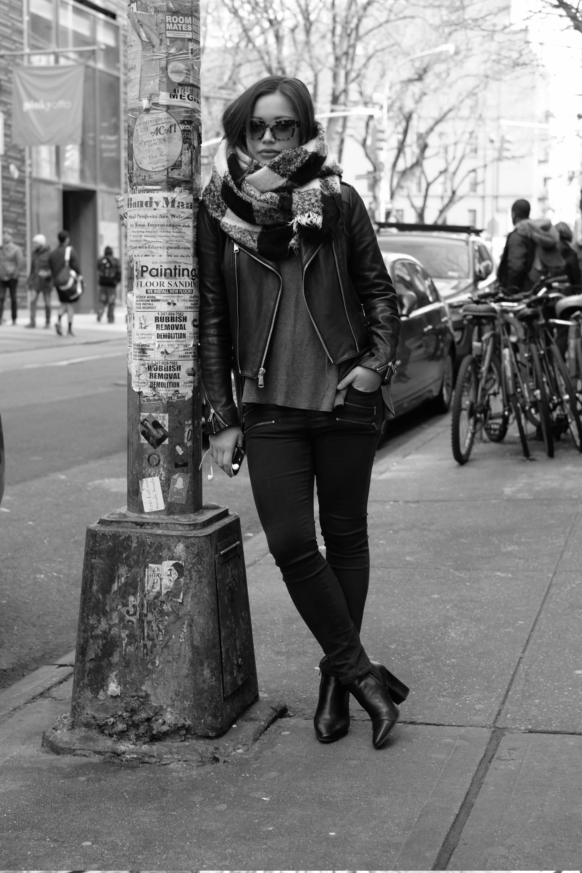 girl leaning on city lamppost