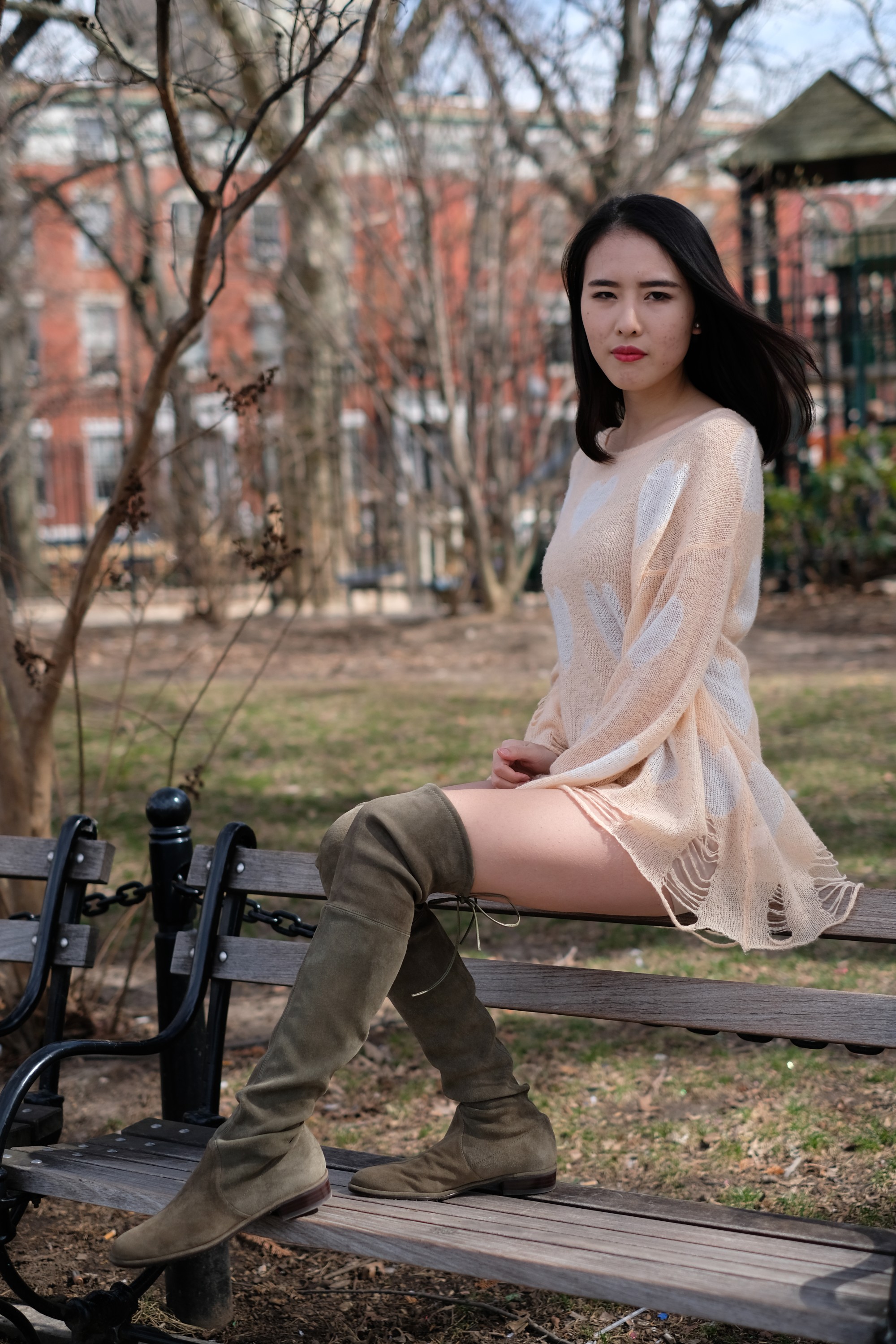 girl in light dress sitting on park bench