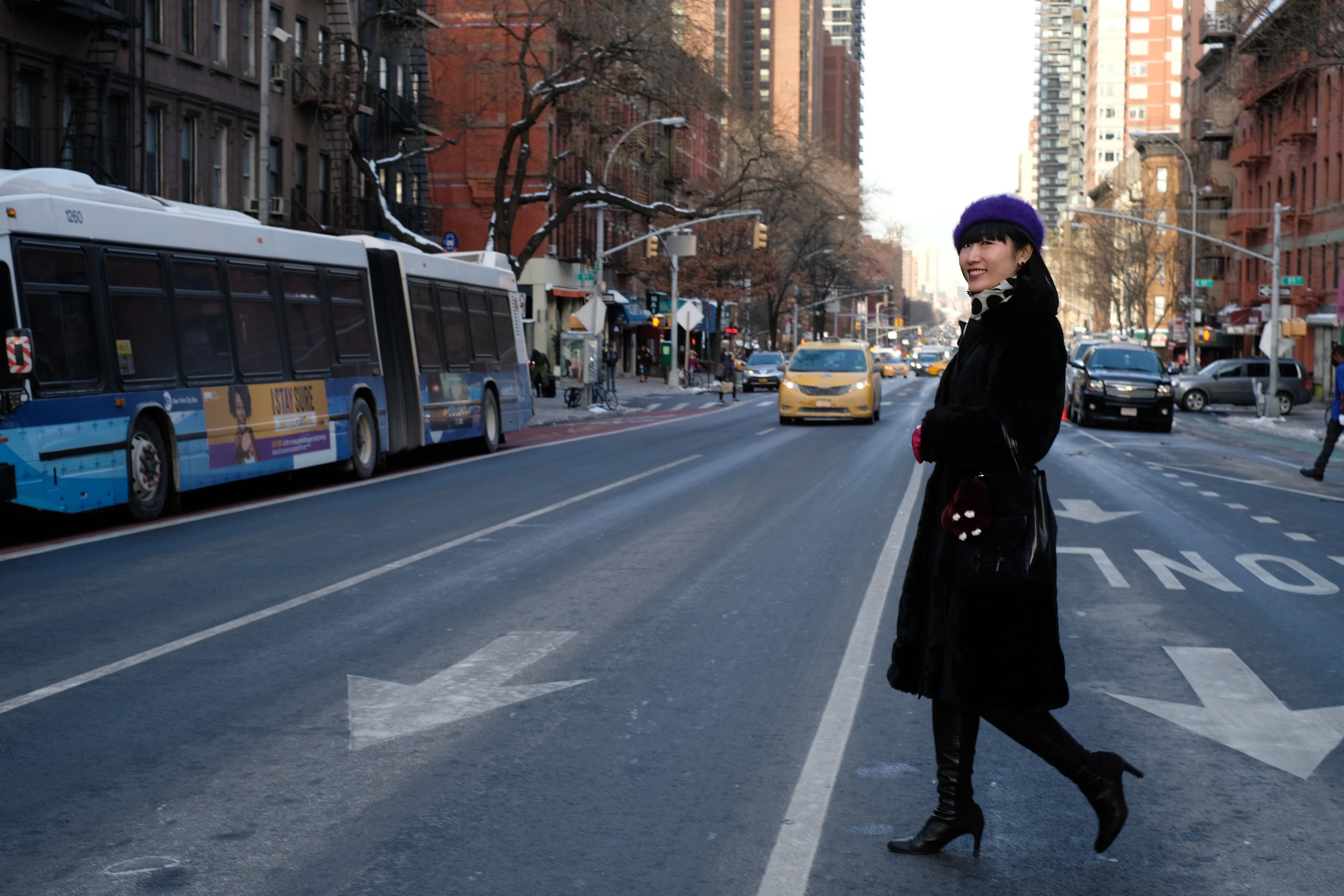 Japanese girl in black coat crossing city street