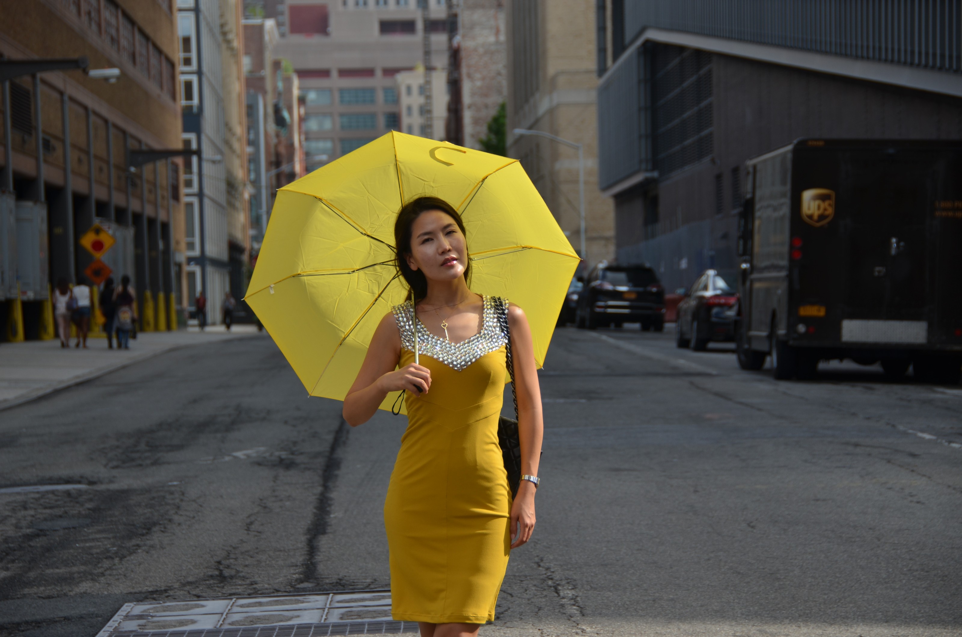 girl in yellow dress and umbrella on city street