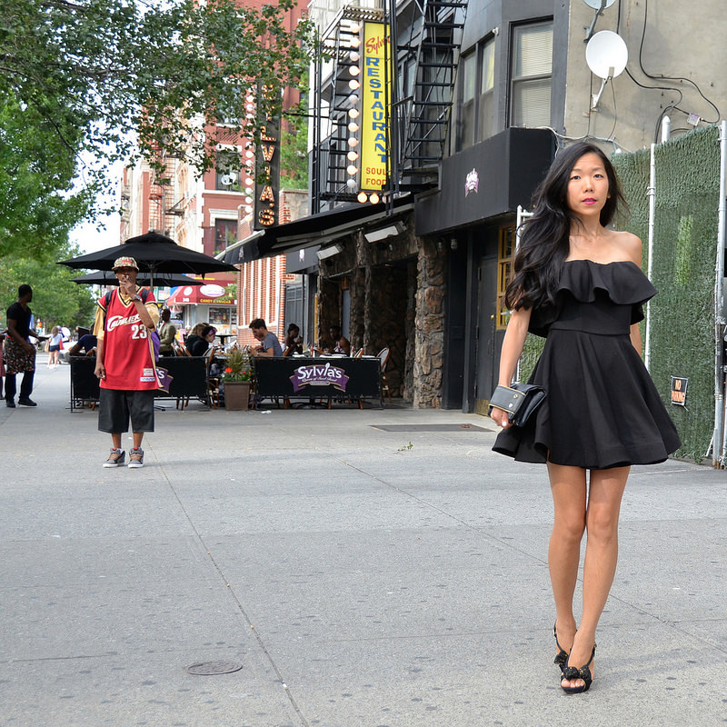 Aya in black dress on sidewalk