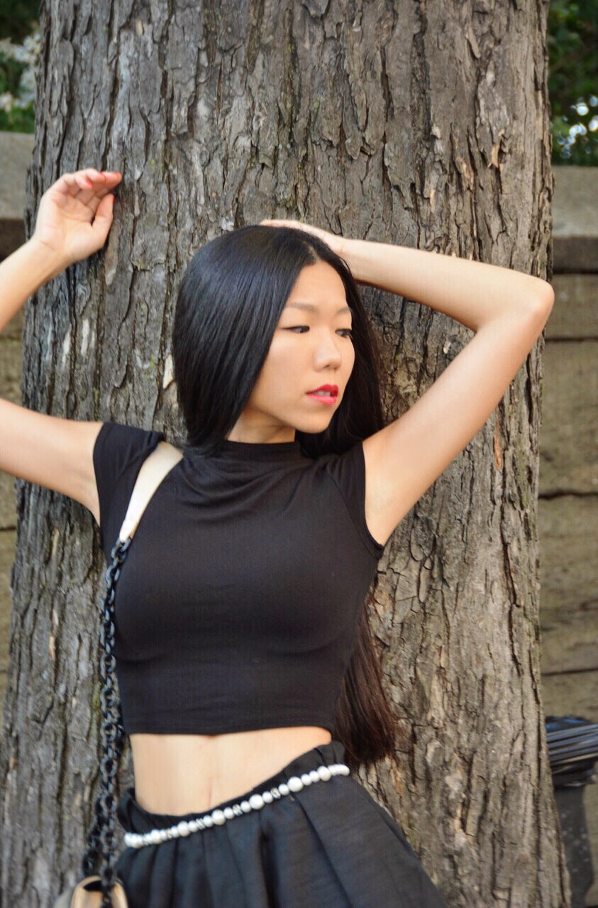 Aya in black dress by a tree