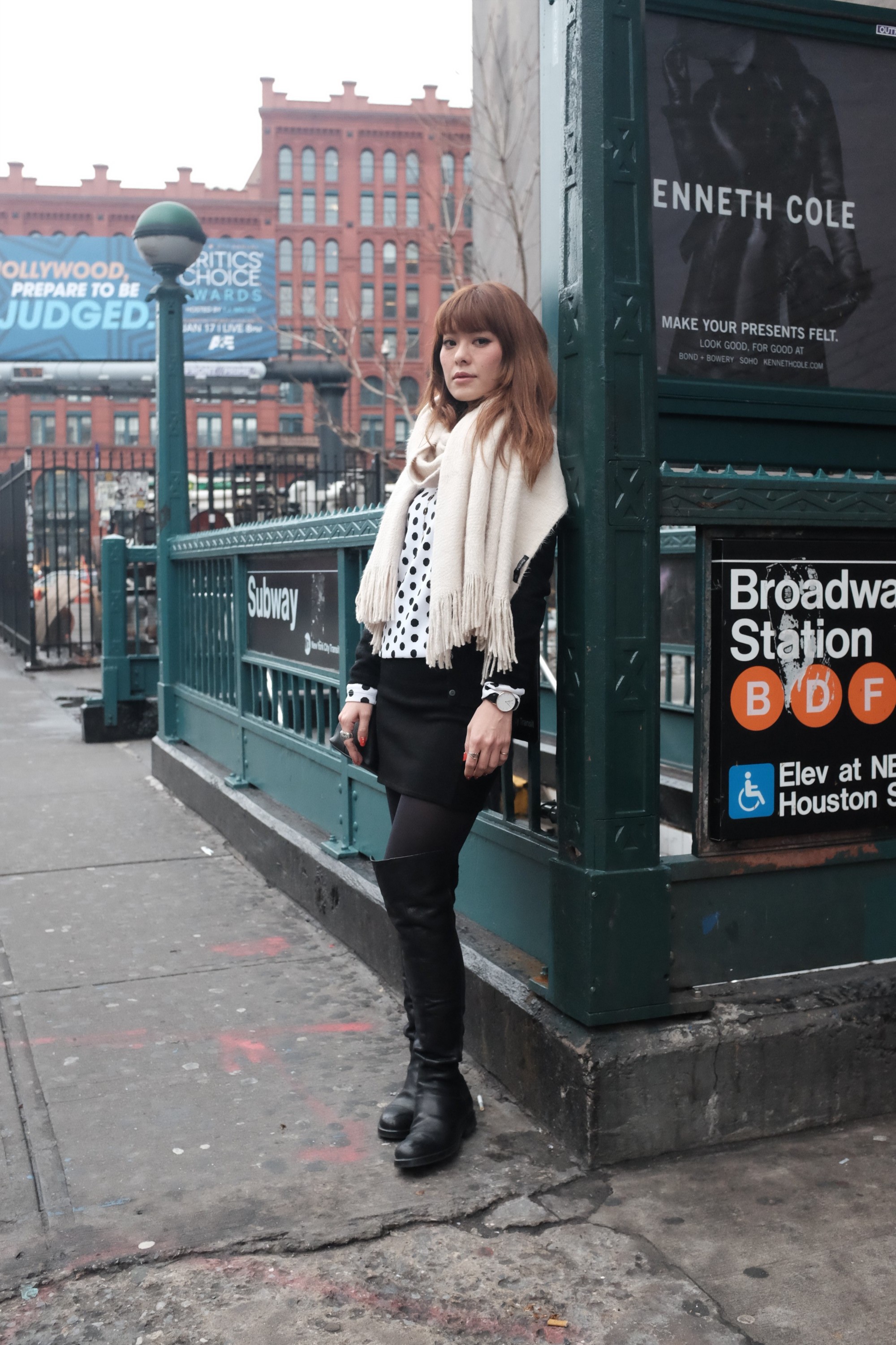 girl in beige scarf standing by subway station
