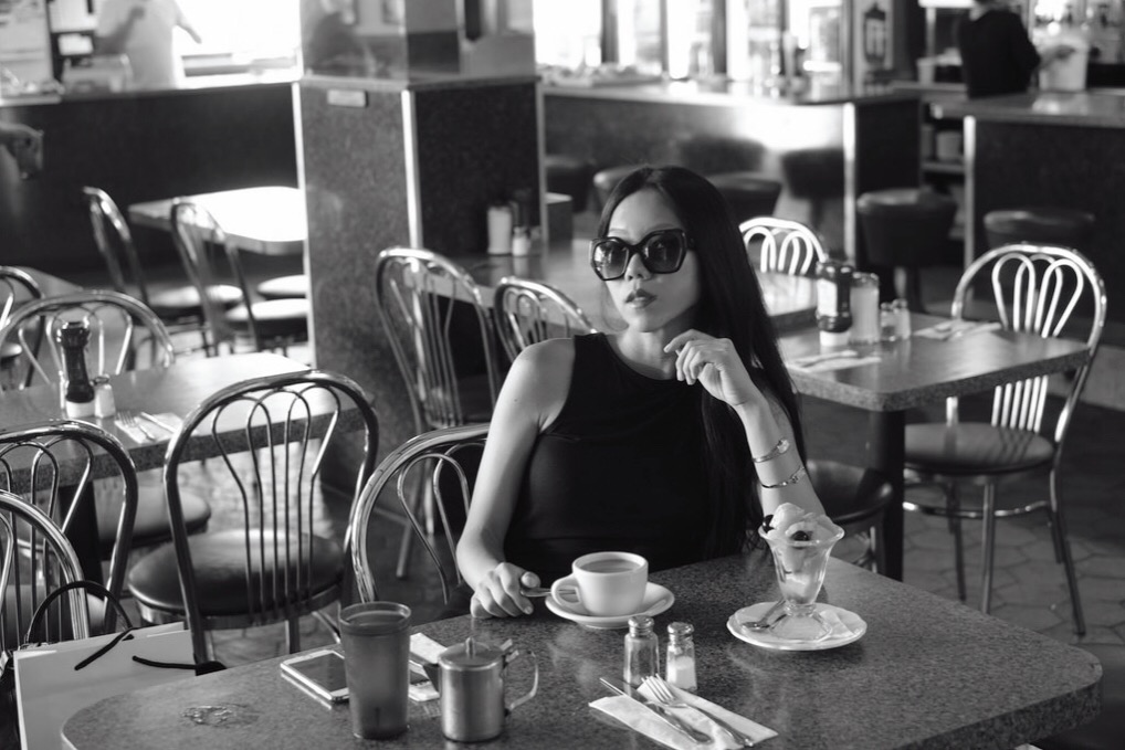 woman in sunglasses sitting in diner
