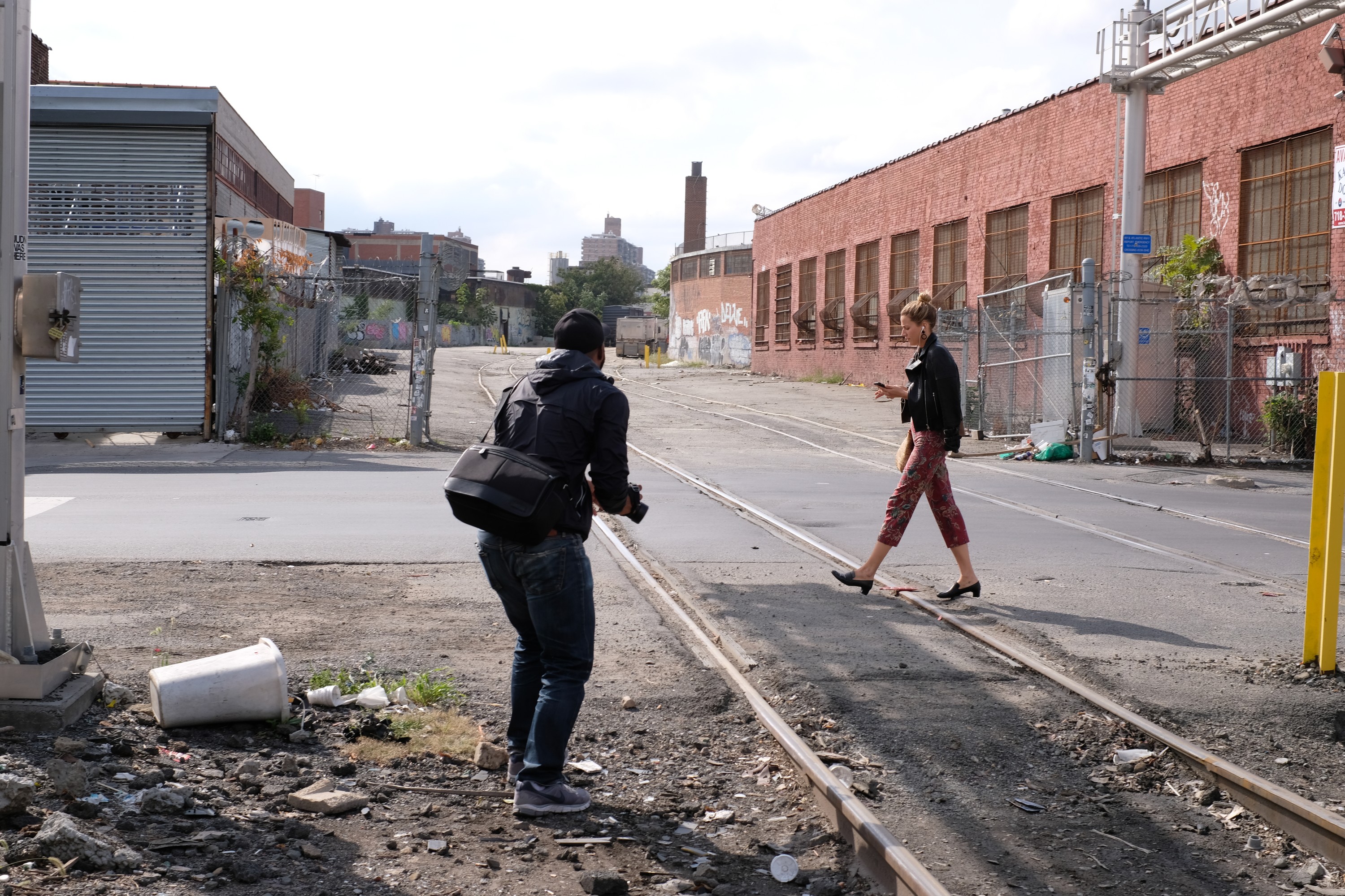 street photographer and woman walkng by train tracks
