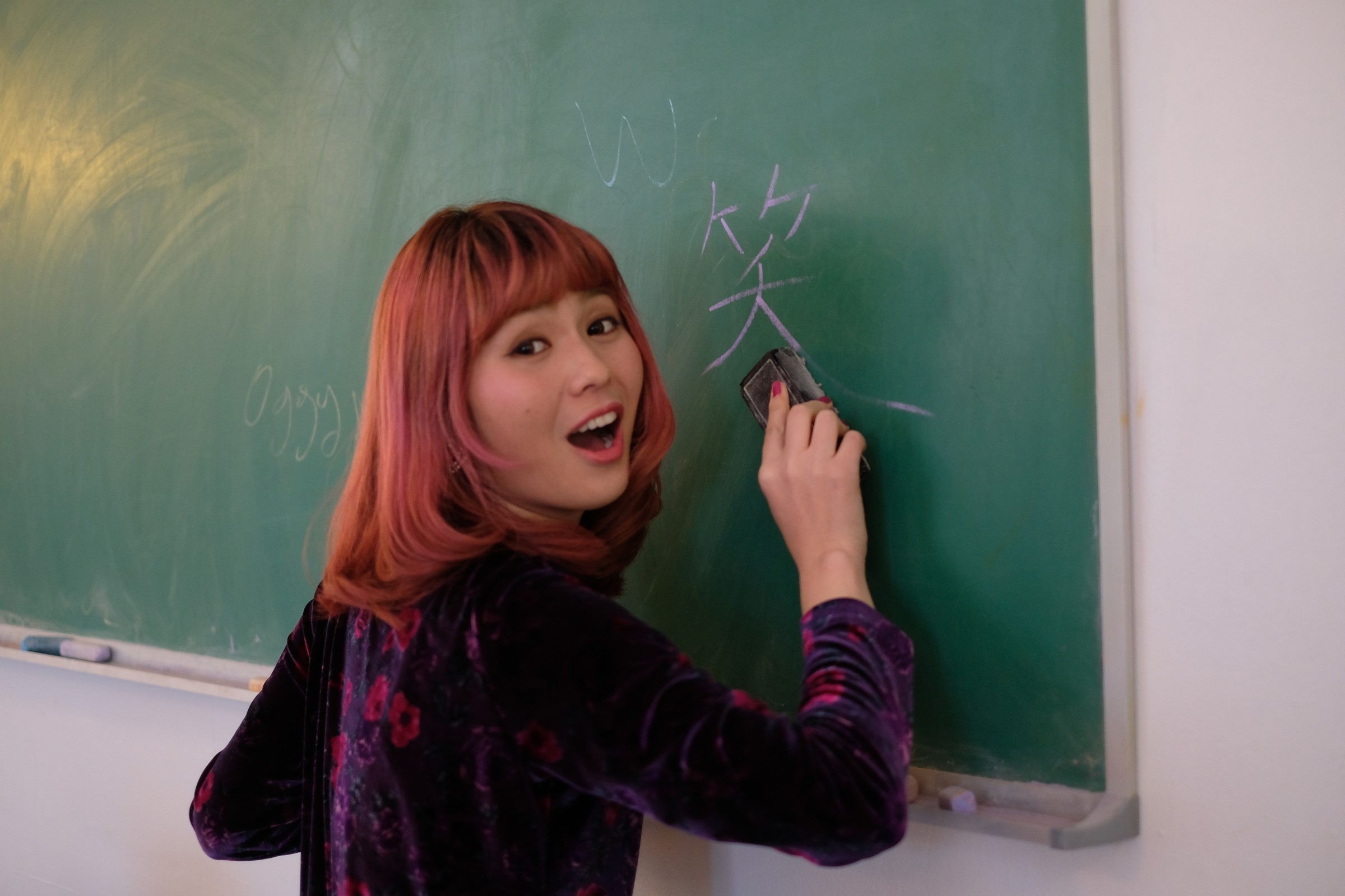 Asian girl writing on chalkboard