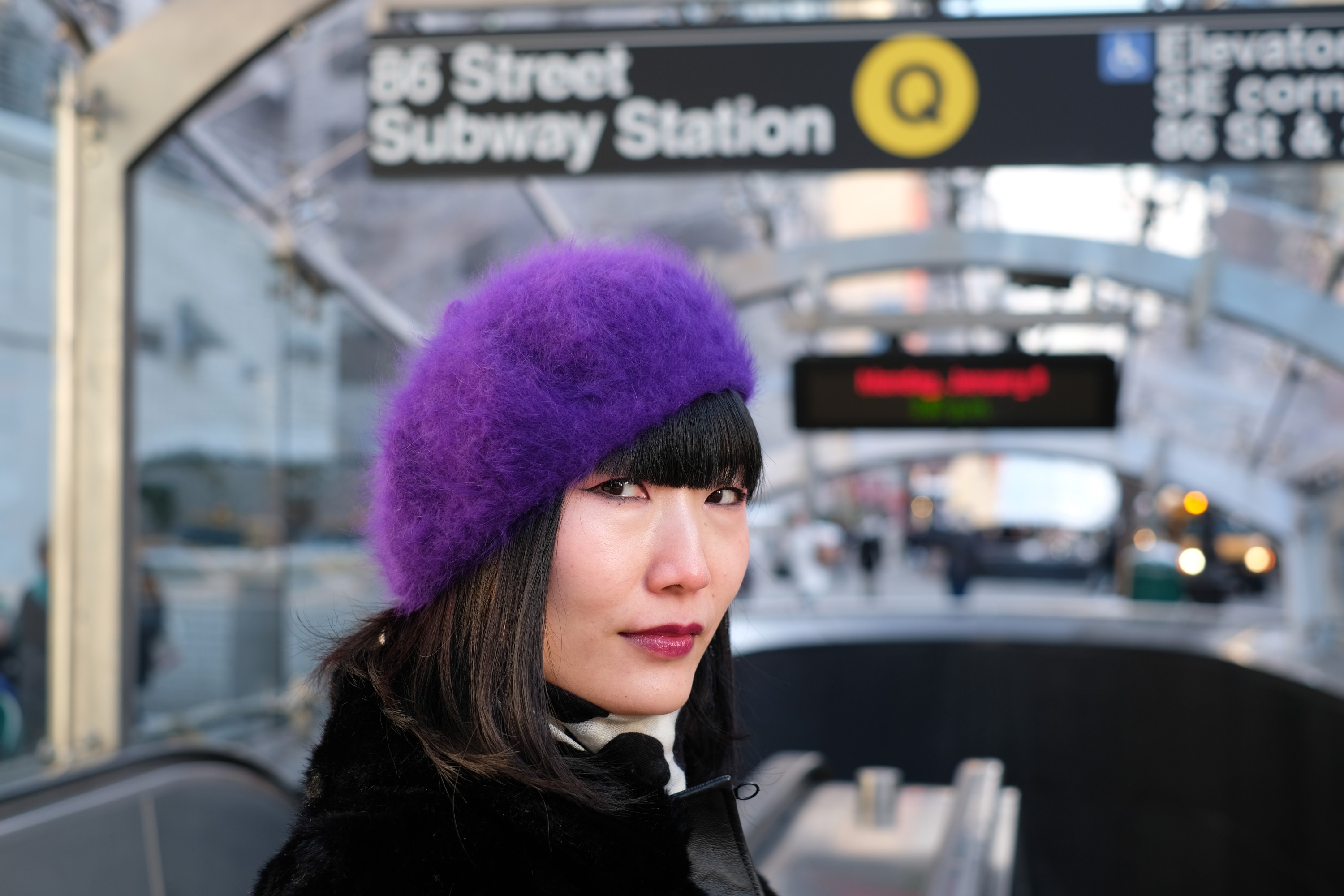 Girl in purple beret in front of subway station
