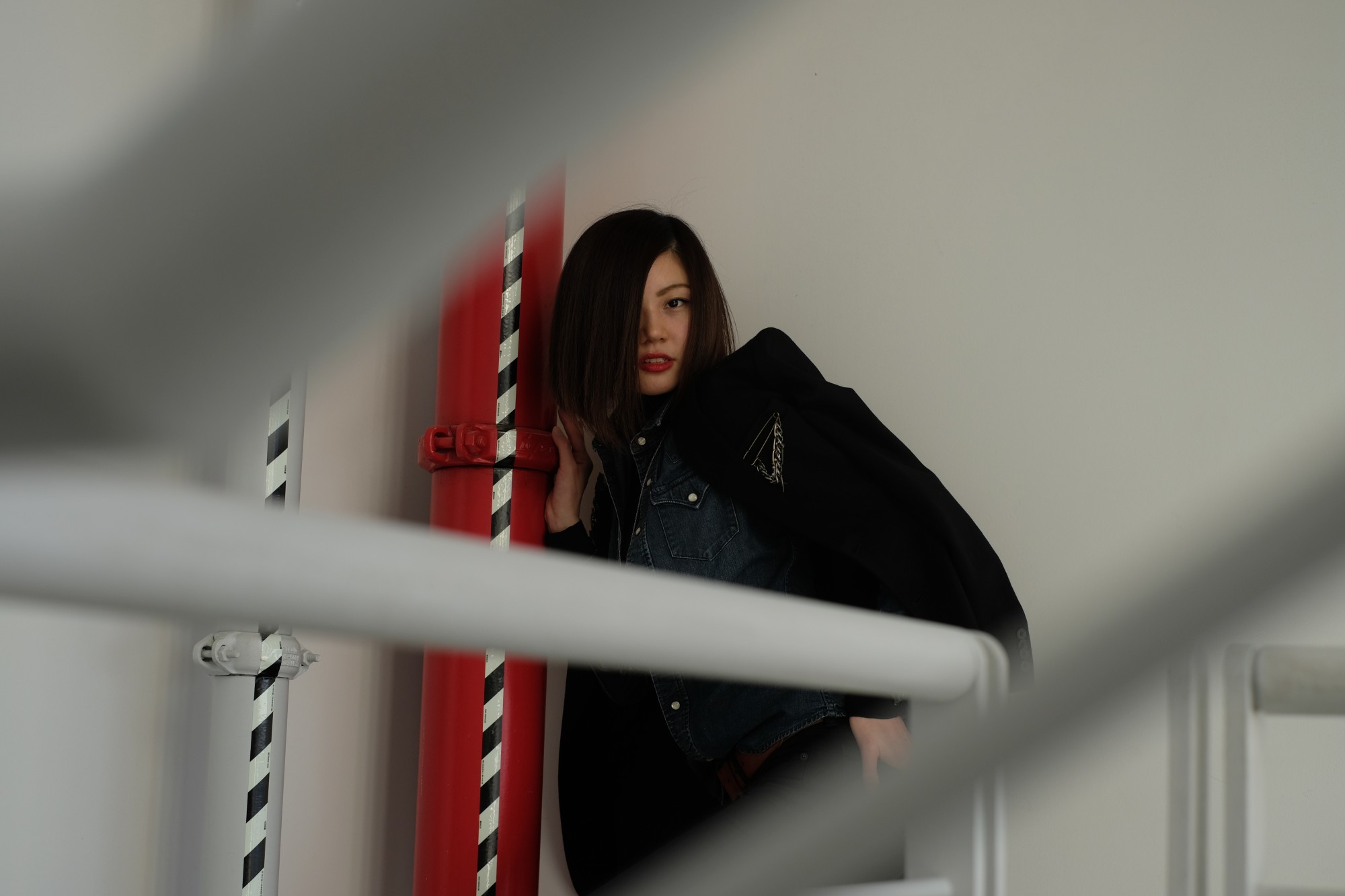 model by red pipe with blurry railings